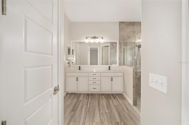 bathroom featuring hardwood / wood-style flooring, vanity, and a shower with shower door