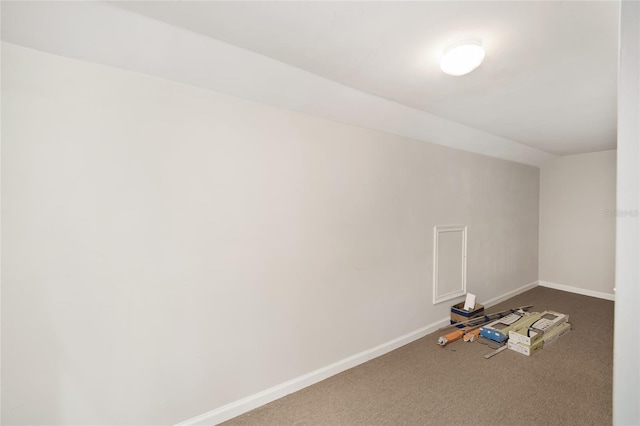 carpeted spare room featuring lofted ceiling