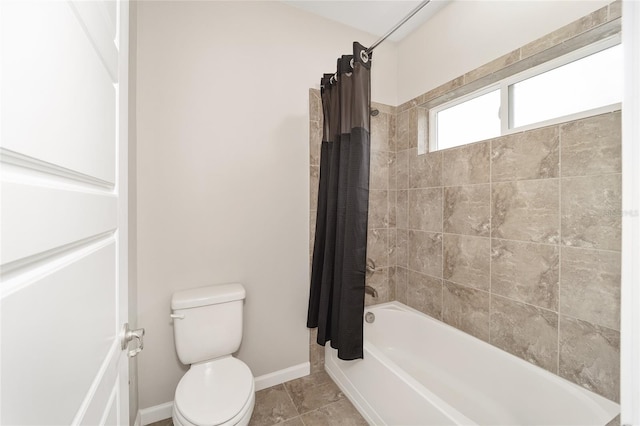 bathroom with shower / bath combination with curtain and toilet