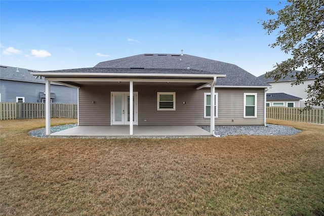 back of house featuring a lawn and a patio