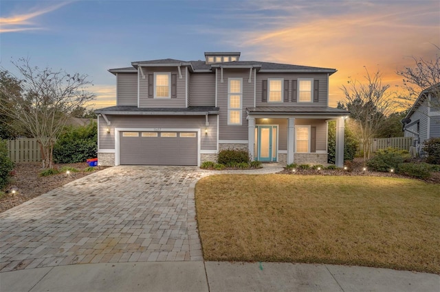 view of front of house featuring a garage and a lawn