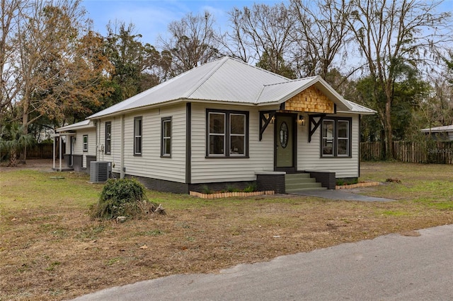 view of front of home featuring a front lawn and central AC