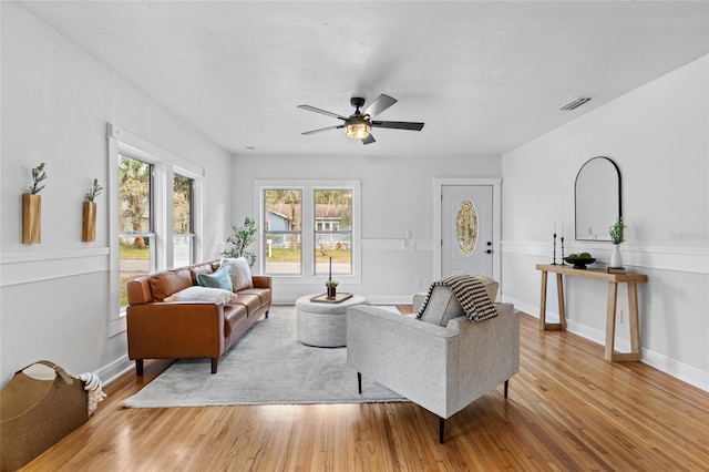 living room featuring a ceiling fan, baseboards, visible vents, and hardwood / wood-style floors