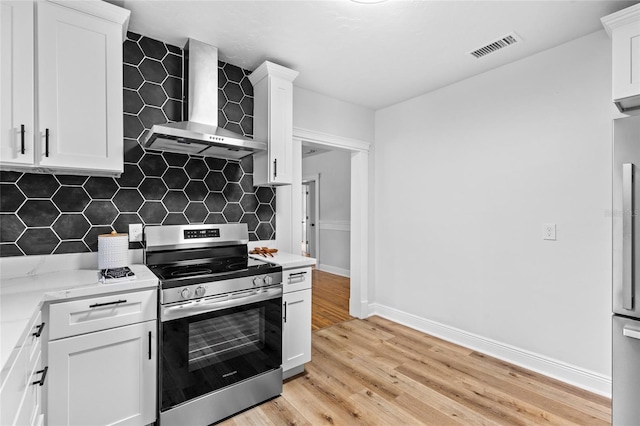 kitchen featuring visible vents, stainless steel electric range, wall chimney exhaust hood, light wood finished floors, and tasteful backsplash