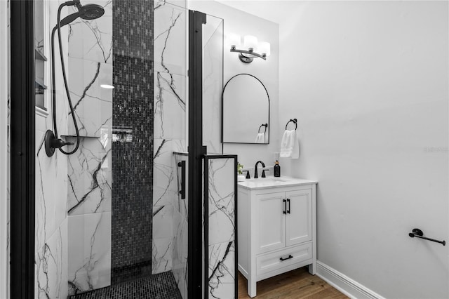 bathroom featuring a tile shower, vanity, and hardwood / wood-style floors