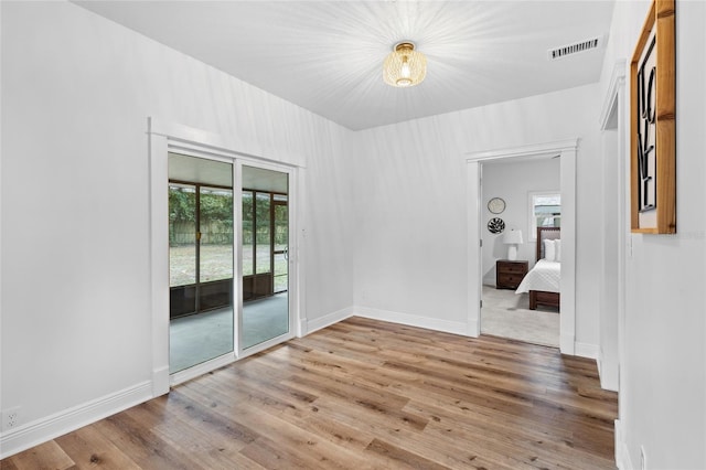 unfurnished room featuring a wealth of natural light, light wood-style flooring, and baseboards