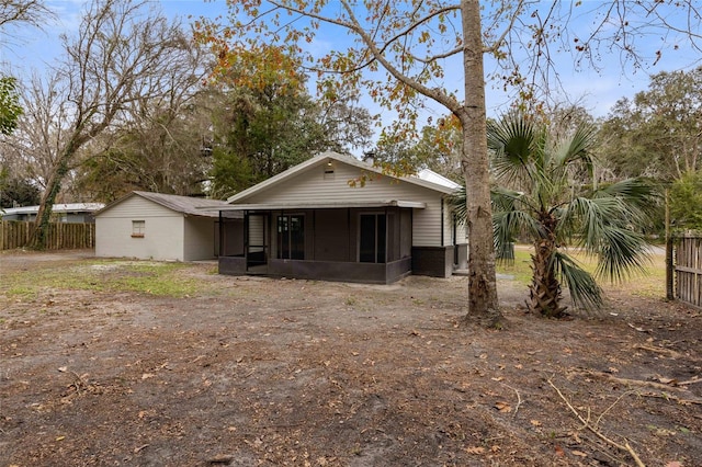 view of front of property with a sunroom and fence