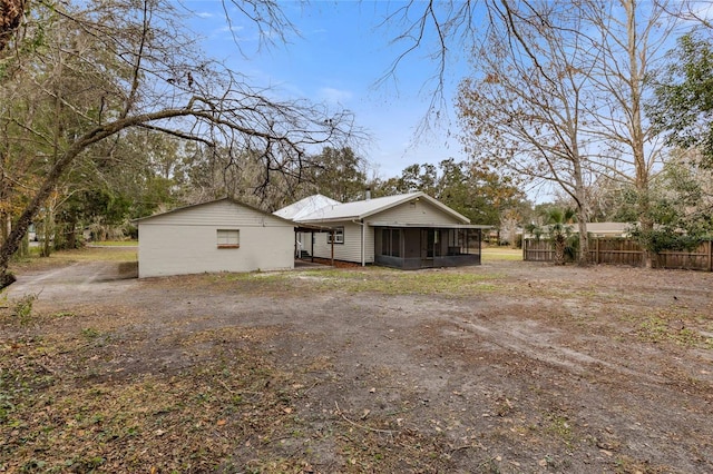 back of property with a sunroom and fence