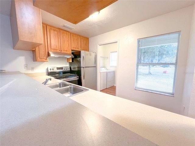 kitchen with sink, stainless steel appliances, separate washer and dryer, and plenty of natural light