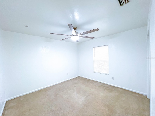 empty room featuring ceiling fan and light carpet