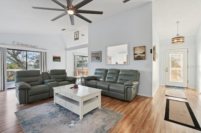 living room featuring light hardwood / wood-style floors, lofted ceiling, and ceiling fan