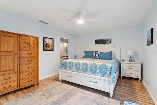 bedroom featuring ceiling fan, connected bathroom, and light hardwood / wood-style flooring