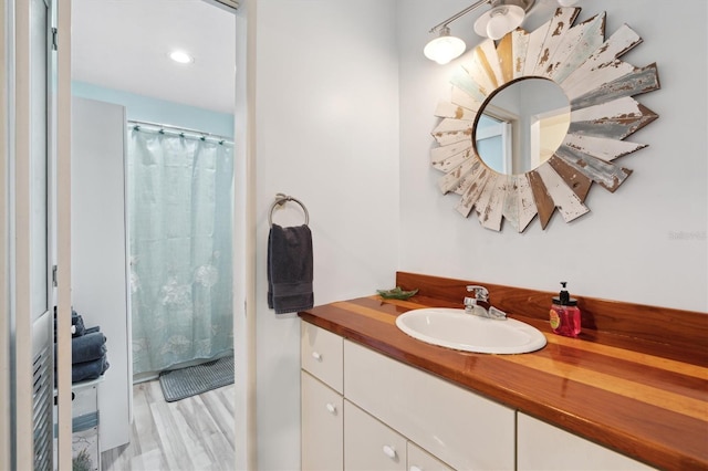 bathroom featuring hardwood / wood-style flooring, vanity, and a shower with curtain