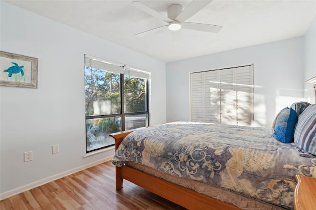 bedroom with ceiling fan, a closet, and hardwood / wood-style floors