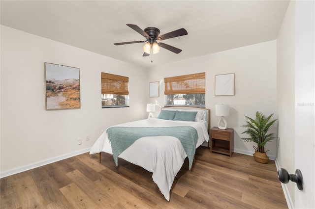 bedroom featuring ceiling fan, baseboards, and wood finished floors