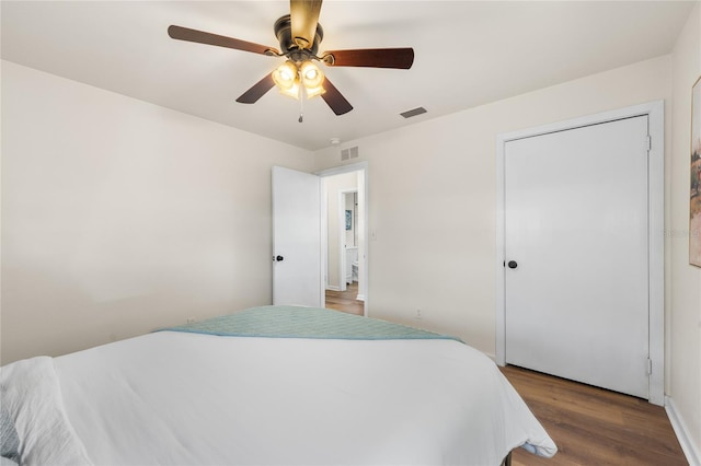 bedroom with ceiling fan, wood finished floors, and visible vents