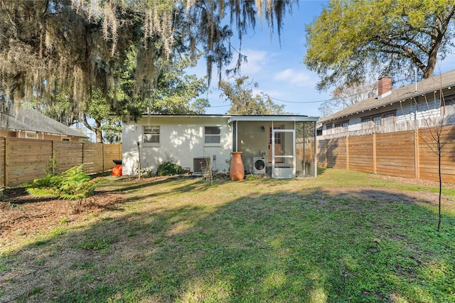 back of house featuring a fenced backyard, cooling unit, and a yard