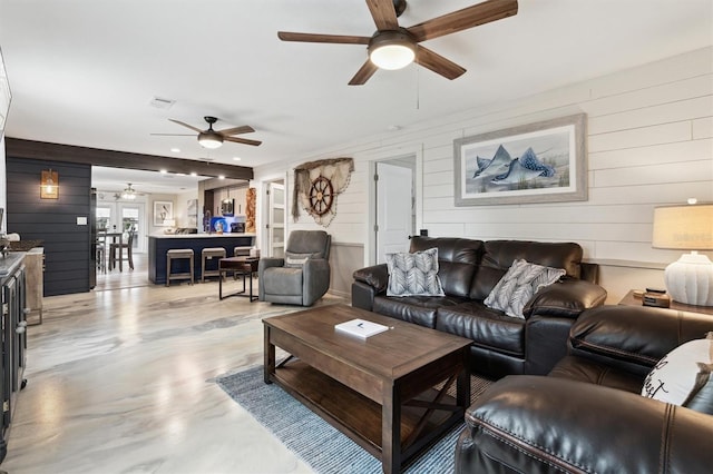 living room with ceiling fan and wooden walls