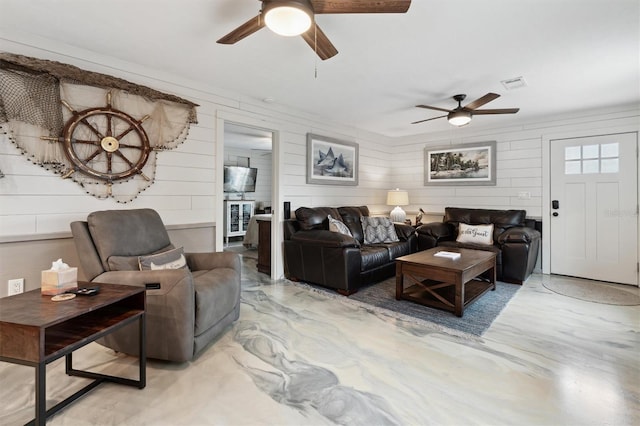 living room featuring ceiling fan and concrete flooring