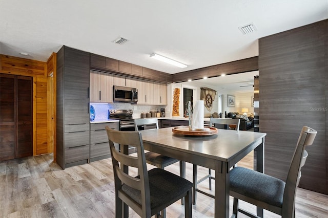 dining room with ceiling fan, light hardwood / wood-style floors, and sink