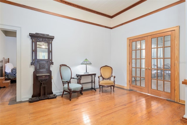 sitting room featuring hardwood / wood-style floors, ornamental molding, and french doors