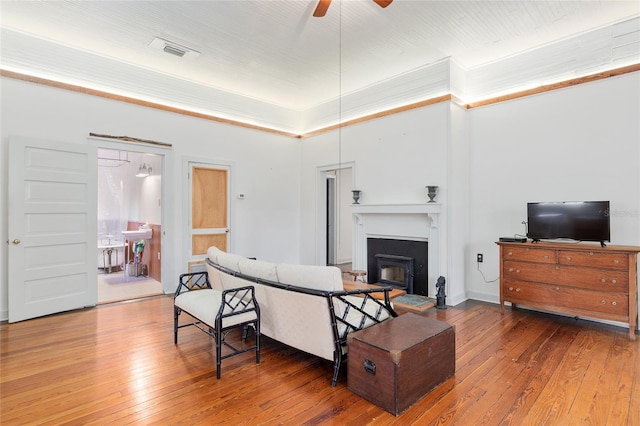 living room featuring ceiling fan, ornamental molding, and hardwood / wood-style floors