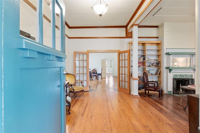 foyer with french doors, ornamental molding, and wood-type flooring