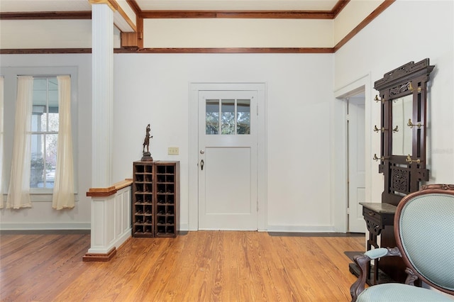 foyer entrance with crown molding and light hardwood / wood-style floors