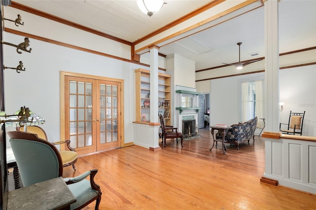 living area with french doors, ornamental molding, and light hardwood / wood-style floors