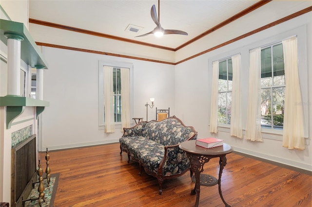 living area featuring ceiling fan, ornamental molding, and hardwood / wood-style flooring