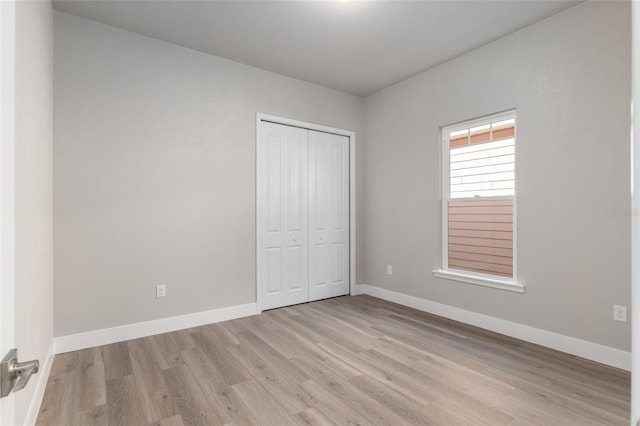 unfurnished bedroom featuring a closet and light hardwood / wood-style flooring