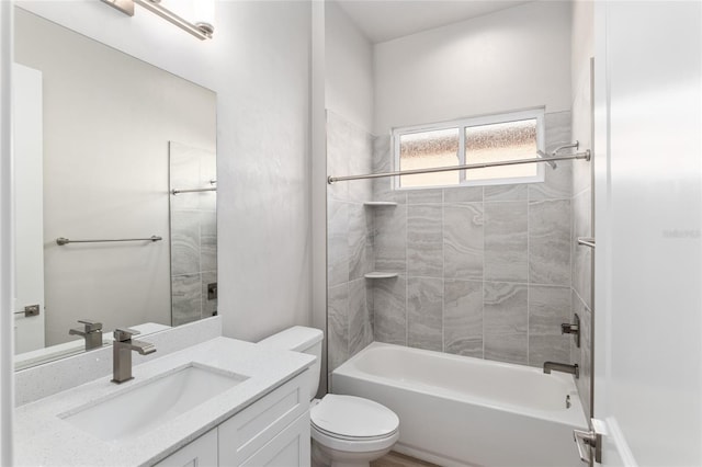 full bathroom featuring toilet, tiled shower / bath, and vanity