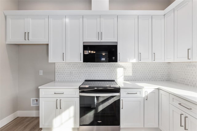 kitchen with tasteful backsplash, stainless steel range with electric cooktop, white cabinetry, and light hardwood / wood-style floors