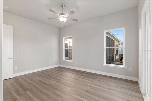 empty room with ceiling fan and light hardwood / wood-style flooring