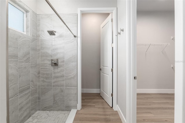 bathroom featuring wood-type flooring and tiled shower