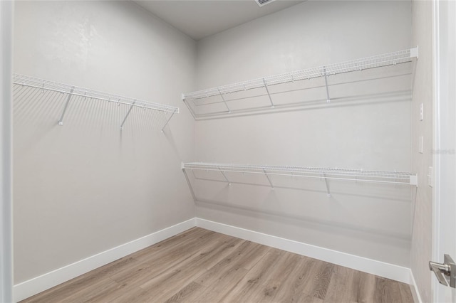 walk in closet with hardwood / wood-style flooring