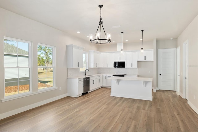 kitchen with dishwasher, white cabinetry, decorative backsplash, a kitchen island, and decorative light fixtures