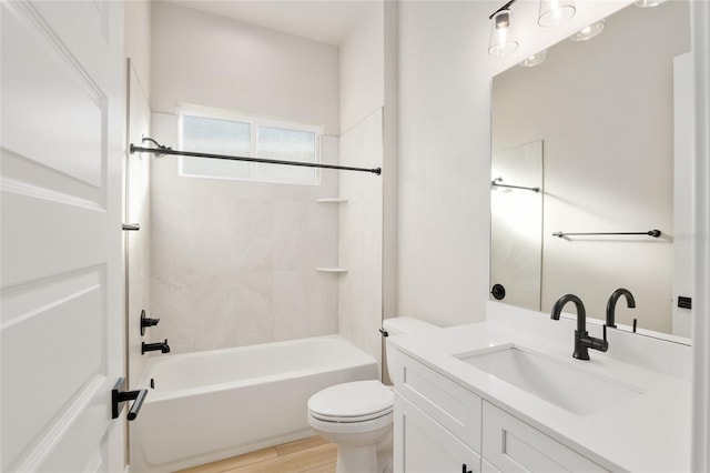 full bathroom featuring tiled shower / bath combo, vanity, hardwood / wood-style floors, and toilet