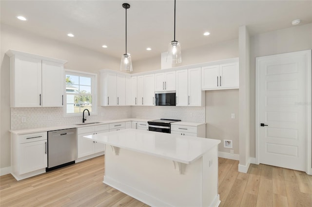 kitchen with sink, white cabinets, hanging light fixtures, a center island, and stainless steel dishwasher