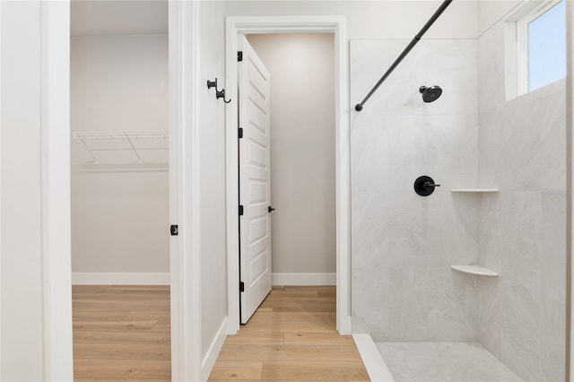 bathroom with wood-type flooring and tiled shower