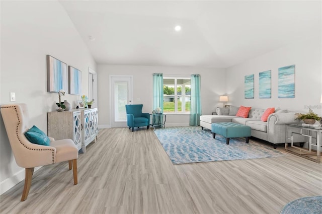 living room featuring light wood-type flooring and vaulted ceiling