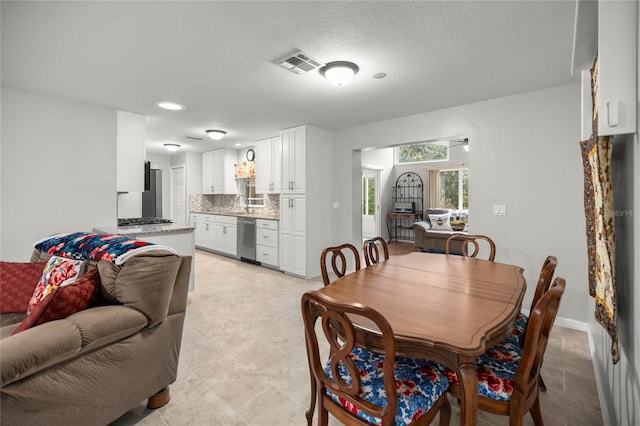 dining space featuring sink and a textured ceiling