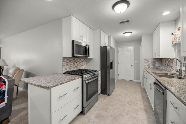 kitchen featuring sink, white cabinets, appliances with stainless steel finishes, and tasteful backsplash