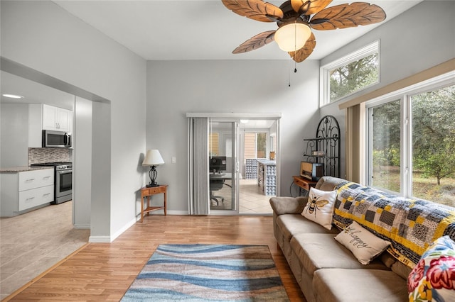 living room with ceiling fan, a wealth of natural light, and light hardwood / wood-style flooring