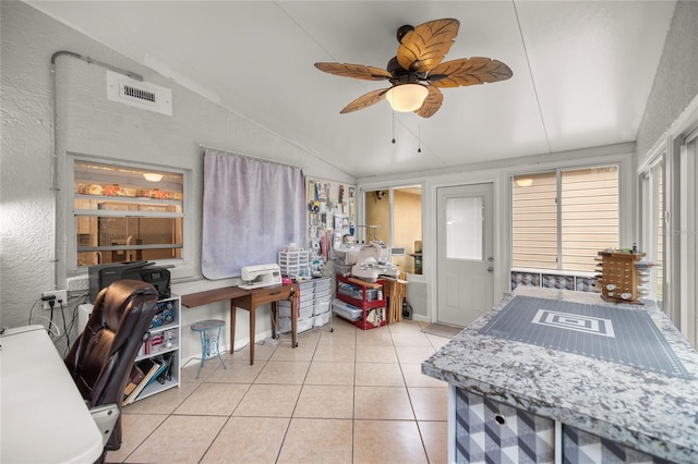 home office featuring lofted ceiling, ceiling fan, and light tile patterned flooring