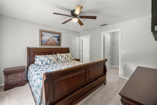 carpeted bedroom featuring ceiling fan, a spacious closet, and a closet