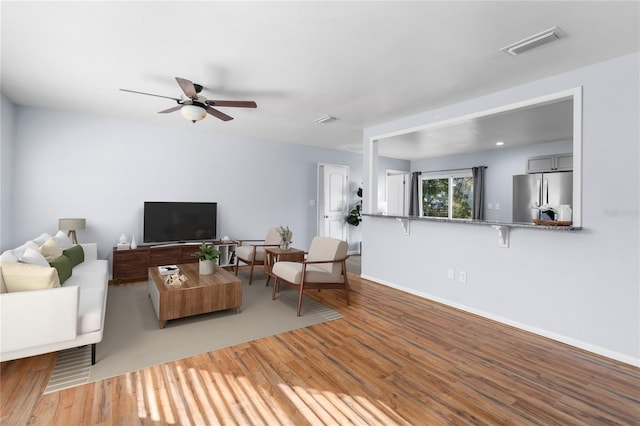 living room featuring ceiling fan and hardwood / wood-style floors