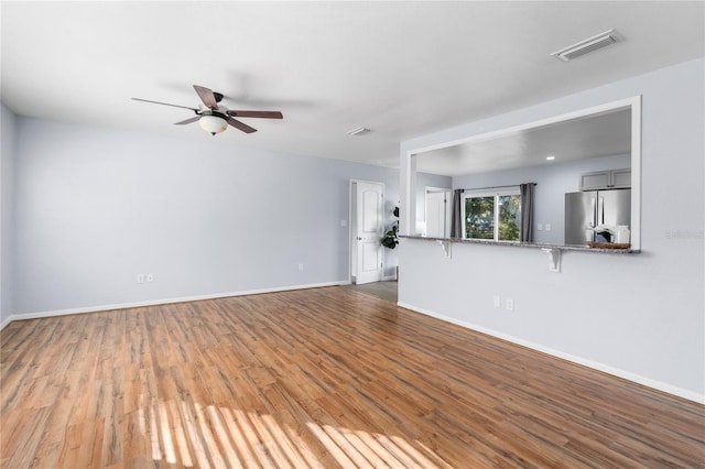 unfurnished living room featuring hardwood / wood-style flooring and ceiling fan