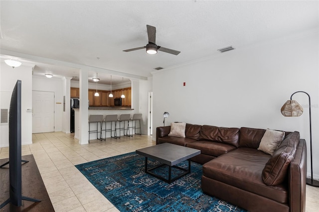 tiled living room featuring ceiling fan and ornamental molding