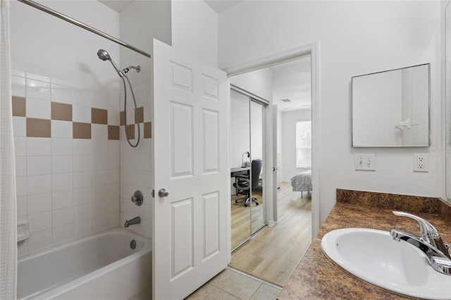 bathroom with tile patterned floors, vanity, and tiled shower / bath